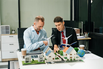 Fototapeta premium businesspeople standing neare table looking at model of building from residential project. Green business company and Solar Energy Environment city