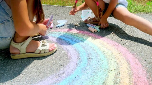 girls drawing with chalk on sidewalk