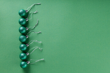 Green Glittery Christmas Balls on Green Background, Minimalist Holiday Concept, Top View, Copy Space