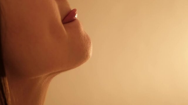 Woman's mouth licks her lips with tongue close-up. Sexy girl body part. Female profile with chin and neck. Side view. Sensual sex foreplay concept. Taste of life. Sexual dreams. Arousal lust. 4K