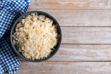 Sauerkraut in a bowl on wooden table. Traditional german food. Top view. Copy space