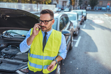 Man in Safety Vest Making Phone Call by Broken Down Car