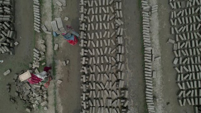 Aerial view of workers carrying bricks at a brick factory, Bahubal, Bangladesh