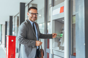 Businessman Smiling While Using ATM Machine Outdoors