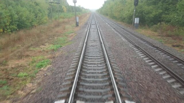 Video shooting on behalf of the train driver through the windshield. Moving forward. Railway. Autumn landscape. Cloudy day.