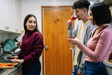 Woman Preparing Dinner While Friends Enjoy Wine