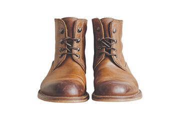 A close-up of a pair of brown leather boots with laces on a green background.