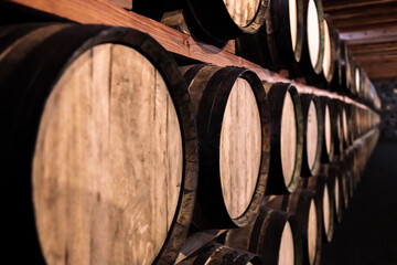aged wine cellar rows of wooden barrels on shelves, concept of viticulture and tradition