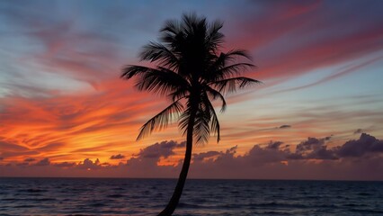 Obraz premium Silhouetted Palm Tree Sunset Beach, A tranquil tropical beach scene at sunset with a palm tree silhouetted against vibrant orange, pink, and blue skies. Calm ocean waves add to the serene atmosphere.