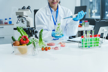 Two Asian women in a lab work on food research, using a microscope, petri dish, and test tubes...