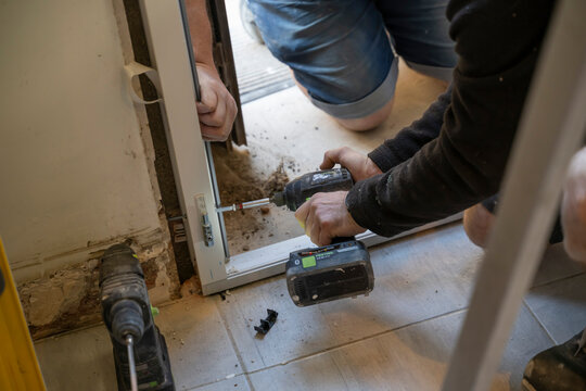 installateurs de porte avec une visseuse pour poser le cadre