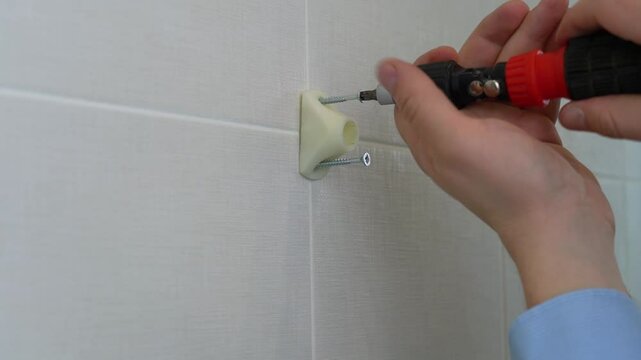 This guide demonstrates the correct method for attaching a wall hook to a tile surface using essential tools and techniques
