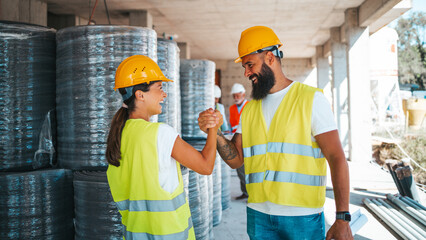Construction Workers Celebrating Team Success with Handshake