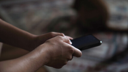 Young boy playing with a mobile phone in his hand