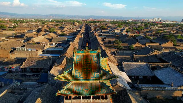 Sunset over Chinese ancient town of Pingyao. Pagoda aerial reveal
