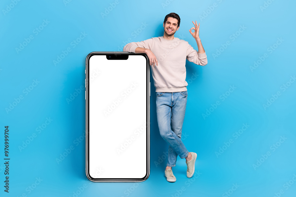 Poster full length photo of cheerful confident guy dressed beige sweatshirt showing okey device empty space