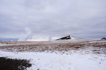Fototapeta premium Leirhnjúkur Volcanic Park, steam rising from the snowy ground in autumn in Iceland
