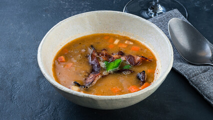 Hot soup with fried bacon, carrots, potatoes and onions.