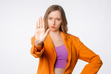Serious young woman showing stop gesture insists on you quitting, rejecting, prohibit something,...