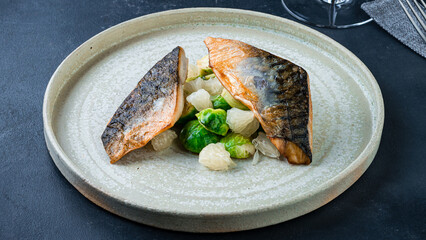 Pieces of fried white fish with Brussels sprouts and pamelo.