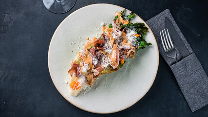 Salad with bacon, parmesan cheese, lettuce, cherry tomatoes and sauce.