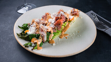 Fresh meat salad with bacon, parmesan cheese, lettuce, cherry tomatoes and sauce.