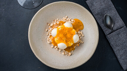 Dessert sweet cream with passion fruit jam and shortbread crumbs in plate.