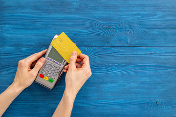 Female holding in hands bank terminal for contactless payment by credit cards. Banking and shopping concept