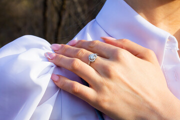 a woman's hand wearing a diamond ring on her finger