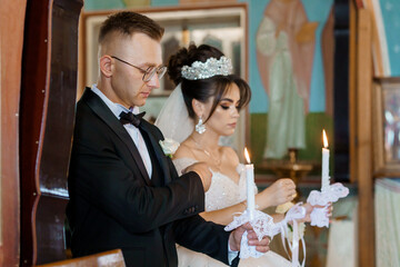 Elegant Wedding Ceremony in Traditional Church Setting with Bride and Groom Lighting Candles
