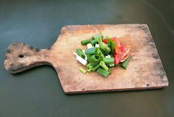 slices of leeks and tomatoes on a wooden cutting board