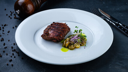 Piece of beef fillet steak with salad and microgreens.