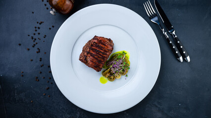 Slice of beef fillet steak with salad and microgreens.