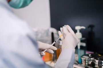 surgery doctor preparing filling syringe medicine for procedure. medical staff preparing therapy operation by adding liquid from vial. cosmetologist ready medicine syringe needle for plastic surgery