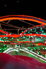 New Year, Christmas multi-colored festive illumination lights up the snow at night. Electric LED garlands on the ground near the sidewalk. Vertical greeting card template, copy space at top and center