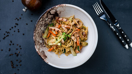 Pasta with chicken, broccoli, zucchini, sweet peppers and sauce.