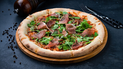 Italian pizza with bacon, sun-dried tomatoes, cheese, arurgula and spices.