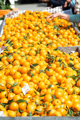 Farmers market stand overflowing with fresh tangerines for sale