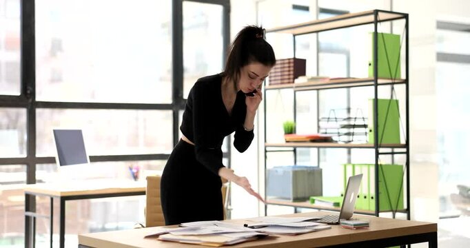 Stressed business woman talking on phone with dissatisfied customer and solving problems remotely. Manager listens to work related complaints and is outraged by financial report