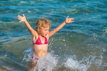 A child bathes and splashes in the sea. Selective focus.