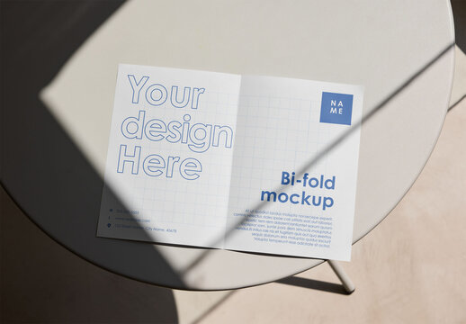 Mockup Of Customizable Open Bi-Fold Leaflet On Table