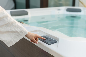 Female choose water temperature in modern hot tub