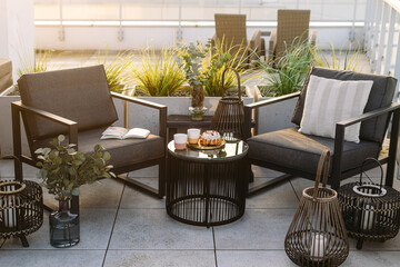 Two modern patio chairs, coffee table and lanterns on balcony