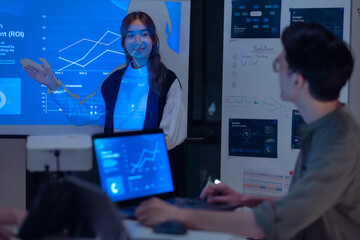asian leader present  business presentation in a dimly lit office, analyzing financial charts and data projections on a screen