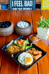 American fried rice with sausages, fried egg, fried chicken, cucumber and tomatoes,Thai style