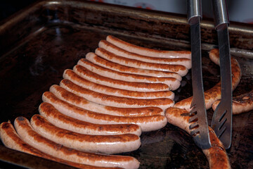 Grilled, juicy, sausages, arranged, on, stove, being, flipped, with, tongs, delicious food concept