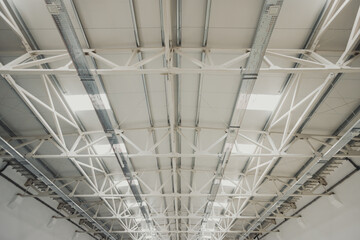 White metal roof frame supporting large industrial building