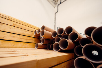 Cardboard tubes stacked on wooden planks in warehouse