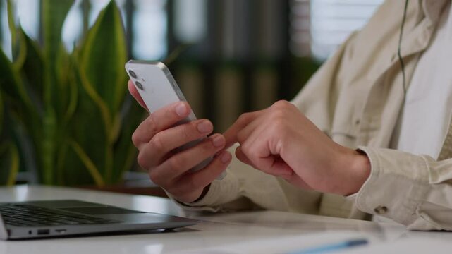 Unrecognizable business man male habds businessman indoors guy worker work laptop computer online office scrolling hold mobile phone app browsing smartphone social media internet screen order delivery