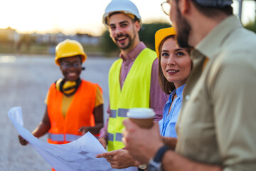 Diverse Construction Team Discussing Blueprints On Site